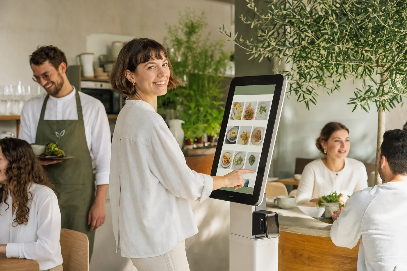 Eine Frau bestellt ihr Frühstück am Bestellkiosk